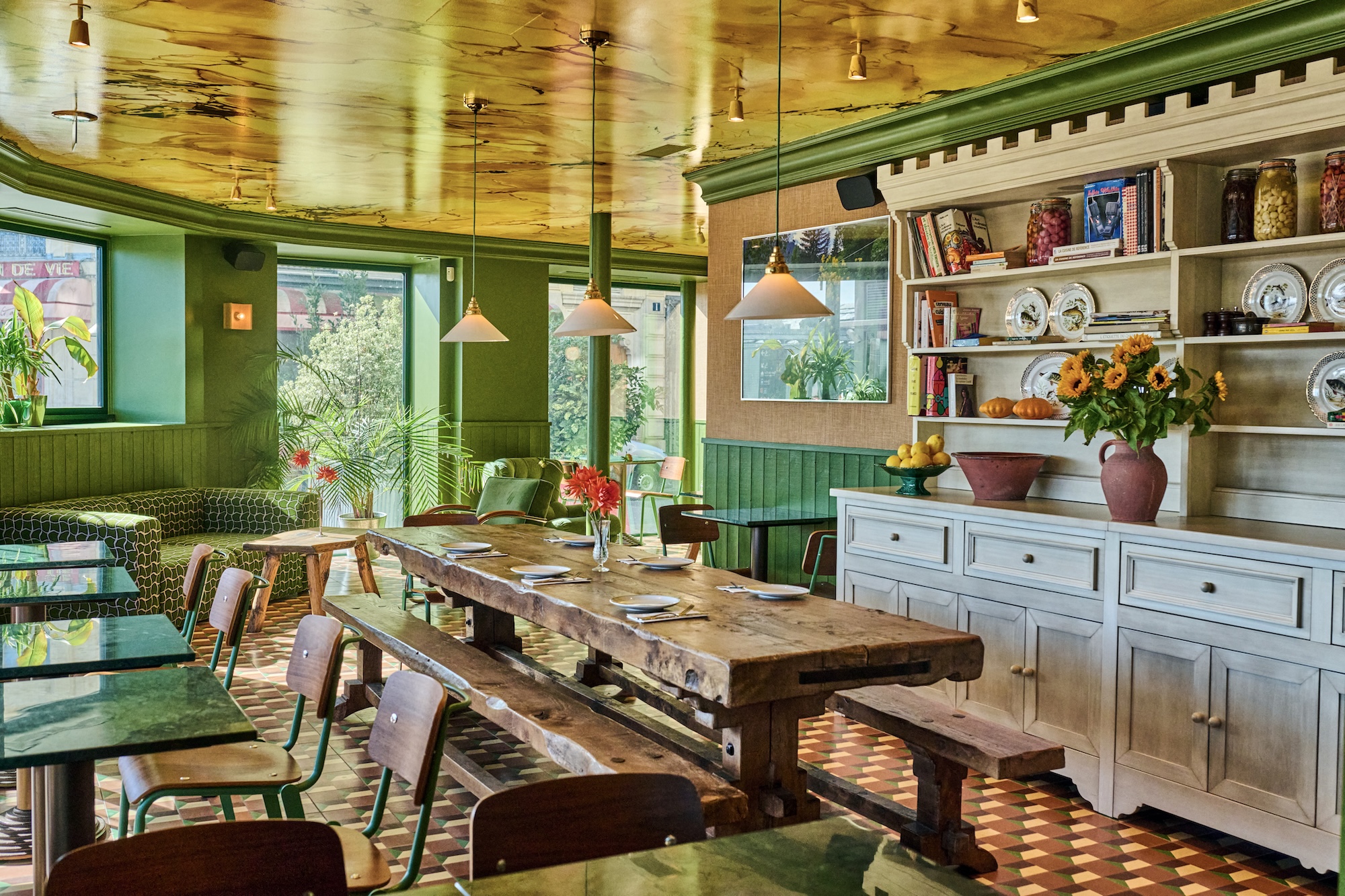 Long wooden table and green walls at Les Deux Gares Express, sister spot of Café Les Deux Gares, Paris 10th
