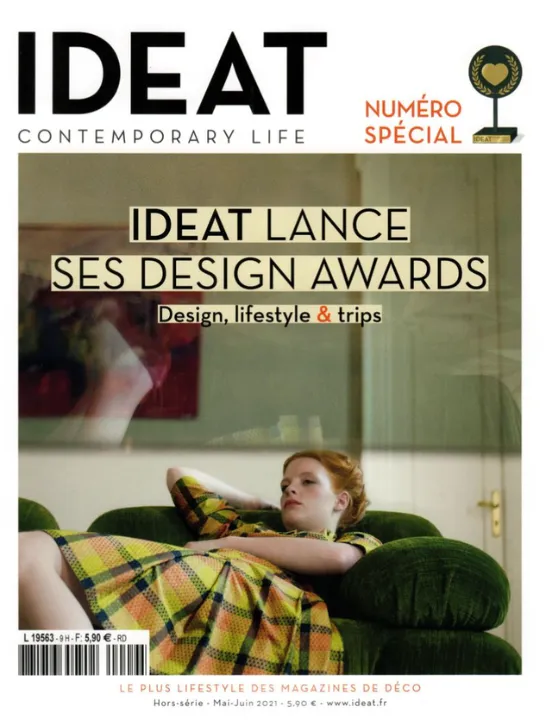 Couverture du hors-série Ideat de mai-juin 2021 consacré à ses Design Awards, avec une femme rousse en robe à carreaux allongée sur un canapé en velours vert.