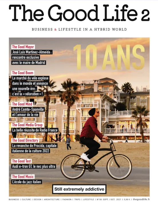 Couverture du numéro anniversaire 10 ans de The Good Life, septembre-octobre 2021, avec un cycliste longeant une plage bordée de palmiers au coucher du soleil.