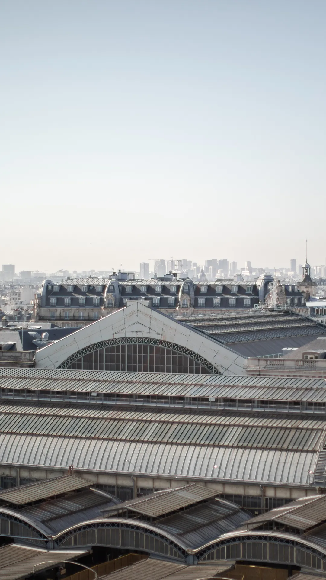 Toits en zinc et verrière de gare sous un ciel clair, à deux pas de l’hôtel entre Gare du Nord et Gare de l’Est, Paris 10e