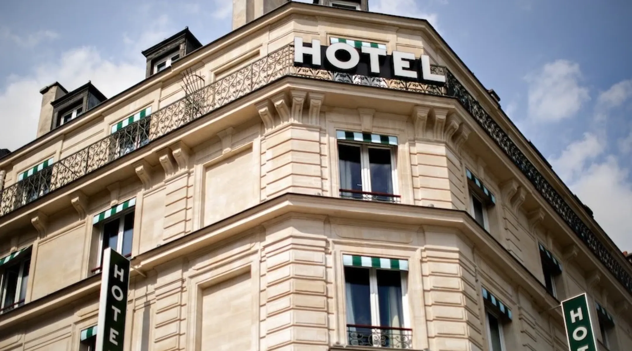 Façade en pierre et enseigne HÔTEL de l’Hôtel Les Deux Gares, lieu de privatisation d’hôtel à Paris 10e