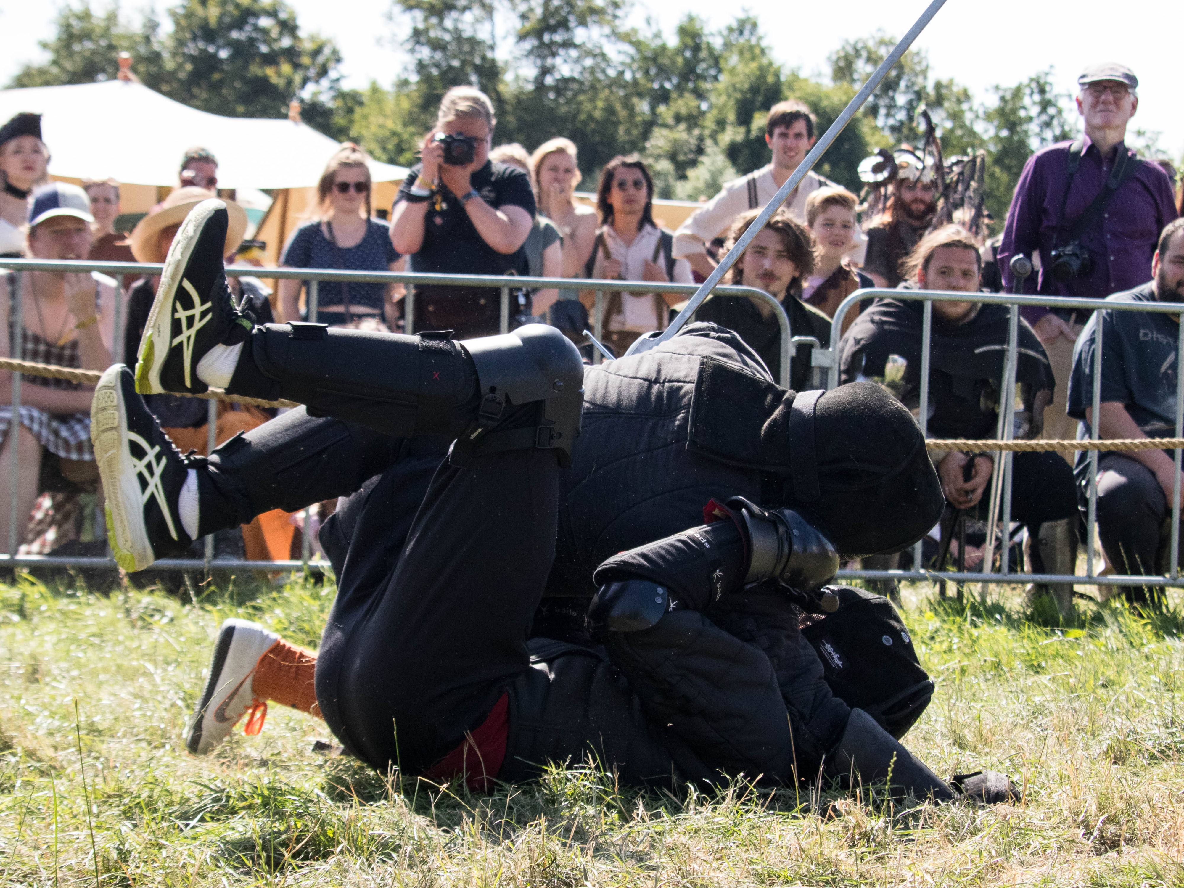 Twee instructeurs worstelen tijdens een demonstratie bij een evenement.