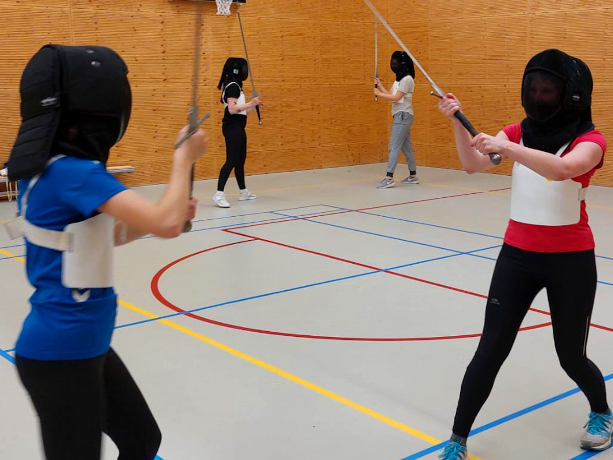 Twee koppels tijden een workshop zwaardvechten.