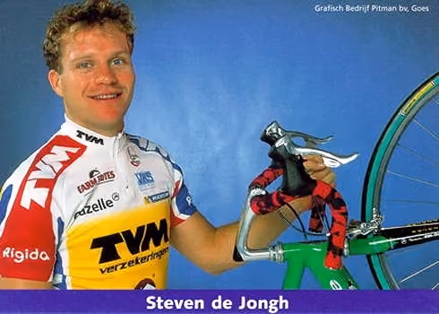 Smiling cyclist Steven de Jongh holding a green racing bike handlebar with red tape.