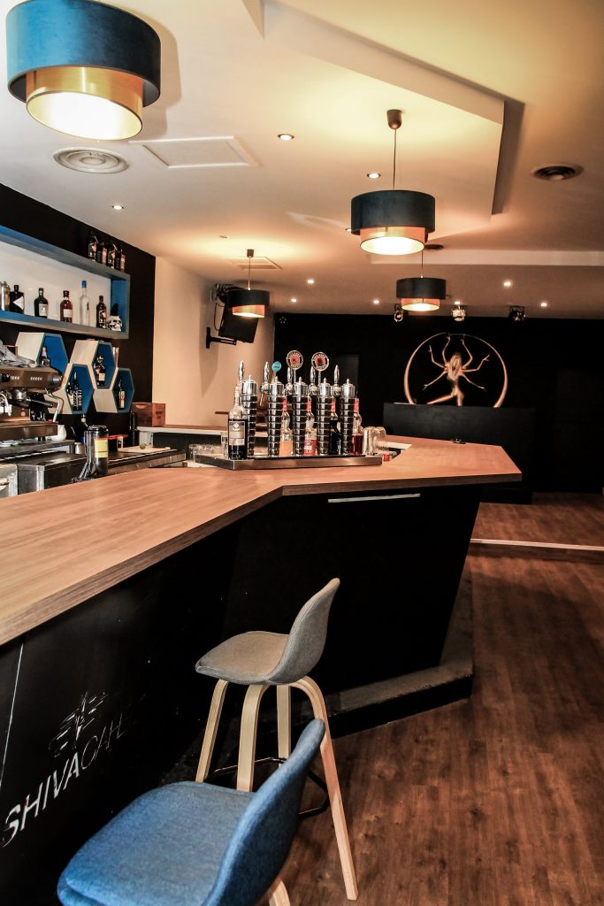 Bar aménagé à Toulouse, comptoir en bois massif et suspensions bleu nuit
