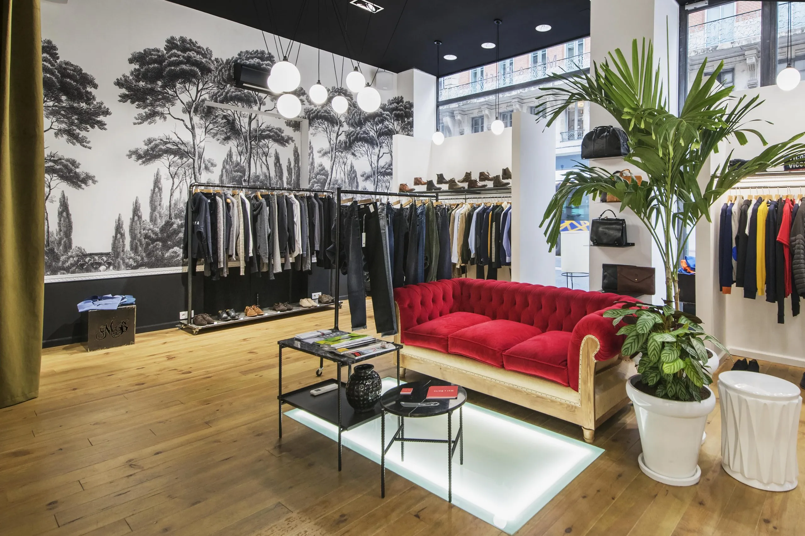 Boutique de prêt-à-porter agencée rue de Metz à Toulouse, papier peint panoramique et canapé de velours