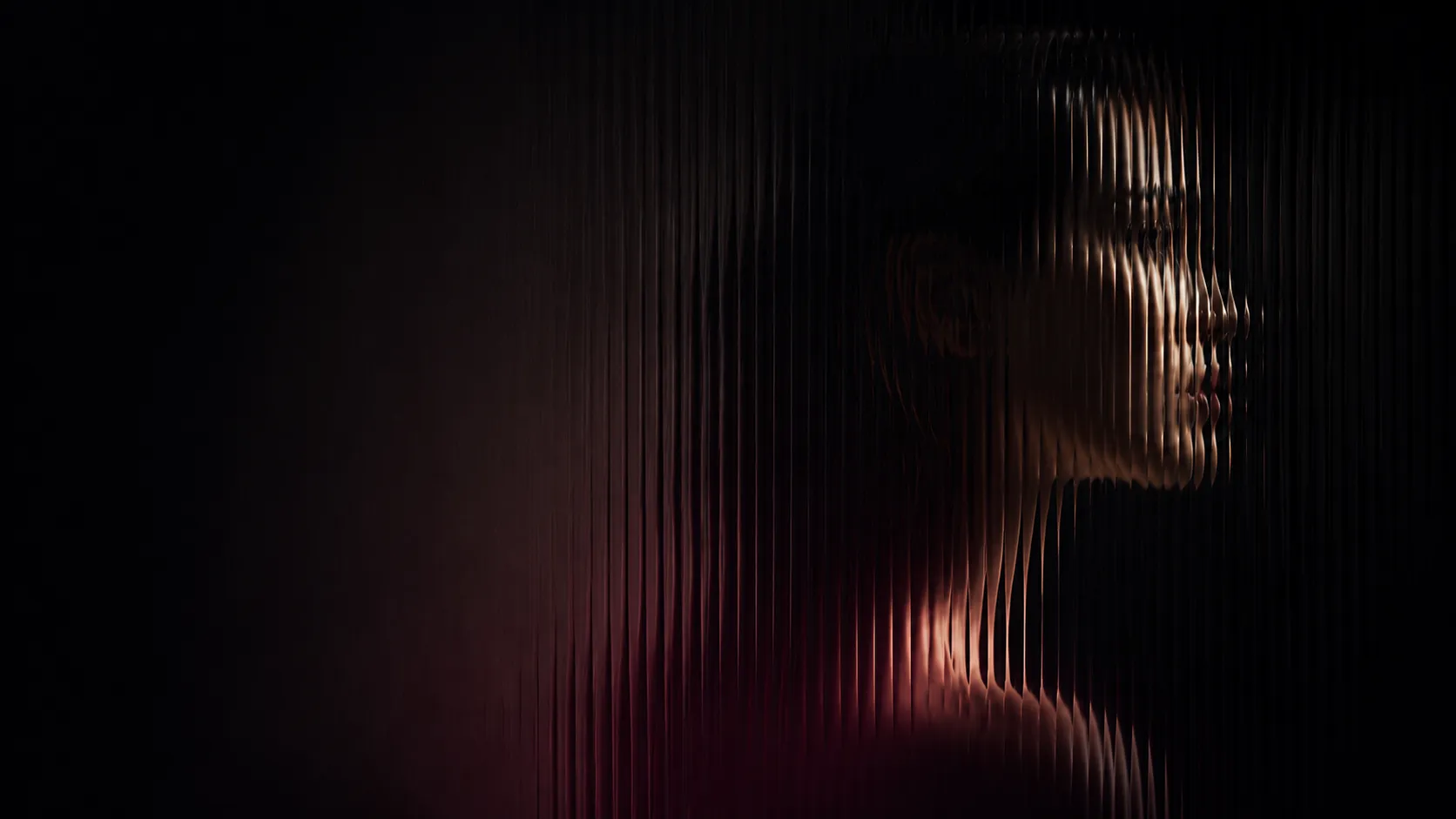 Side profile of a woman's face and neck distorted by vertical textured glass with dark background.