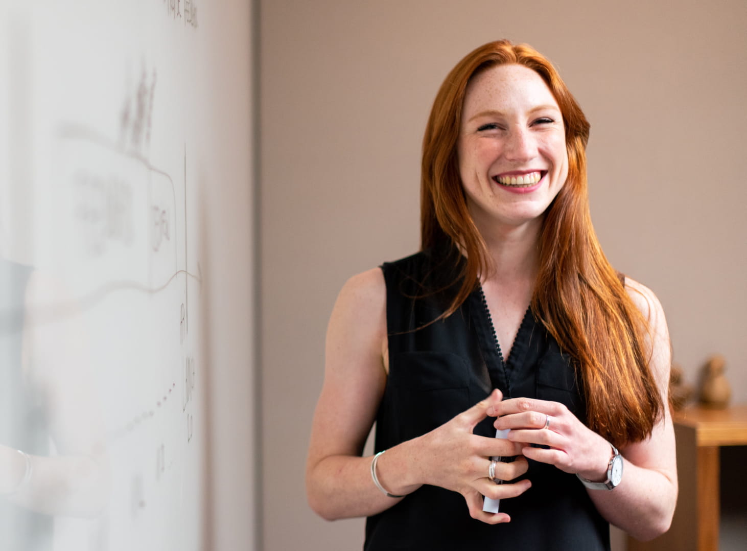 Smiling ginger haired woman stood in a meeting room