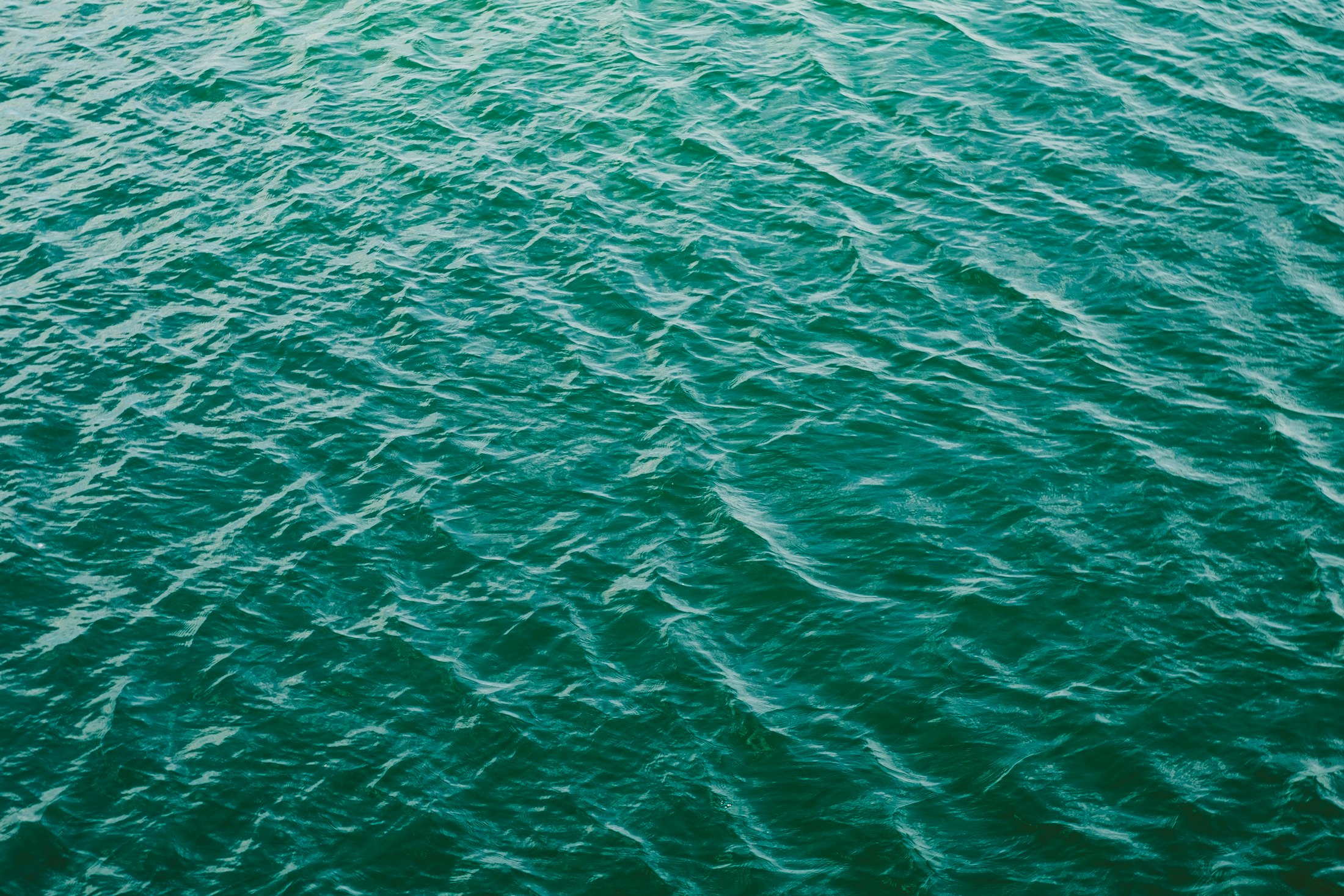 Deep teal sea surface with soft even ripples