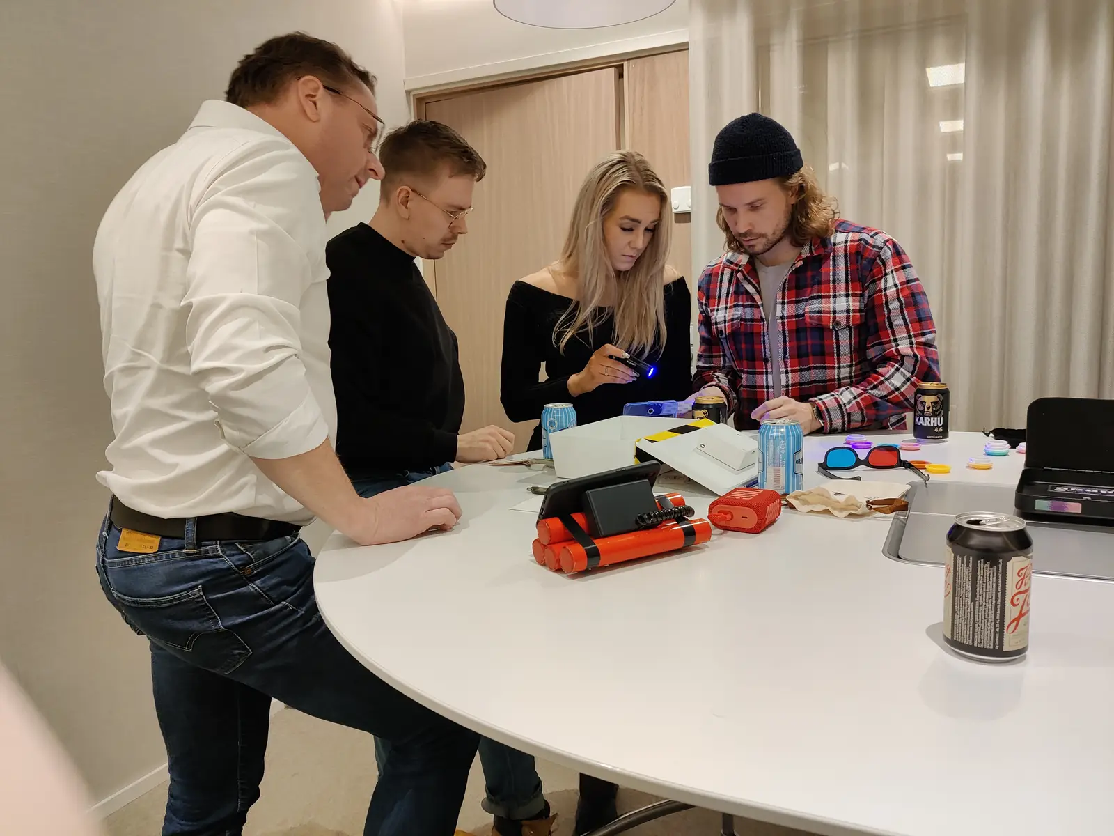Osallistujat tutkimassa pelimateriaaleja pöydän ääressä