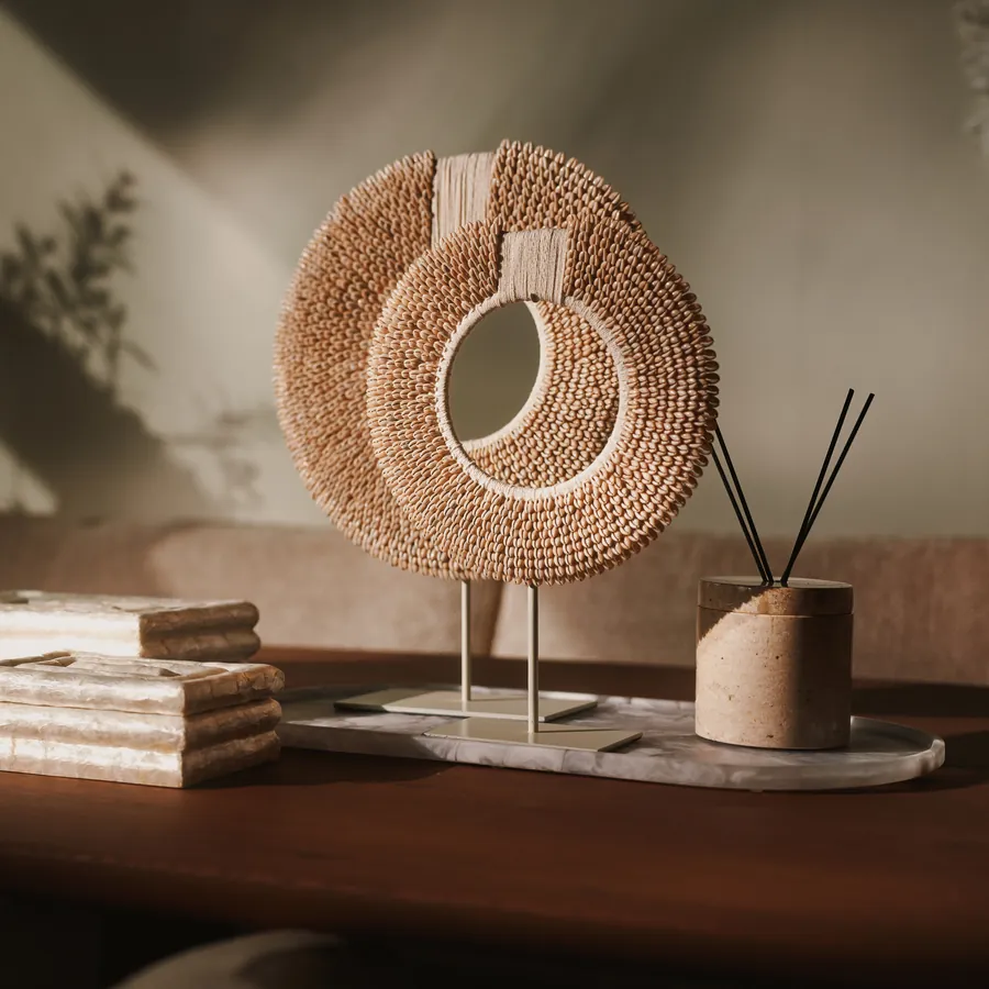 Schelpenringen op standaard met geurstokjes op een houten tafel