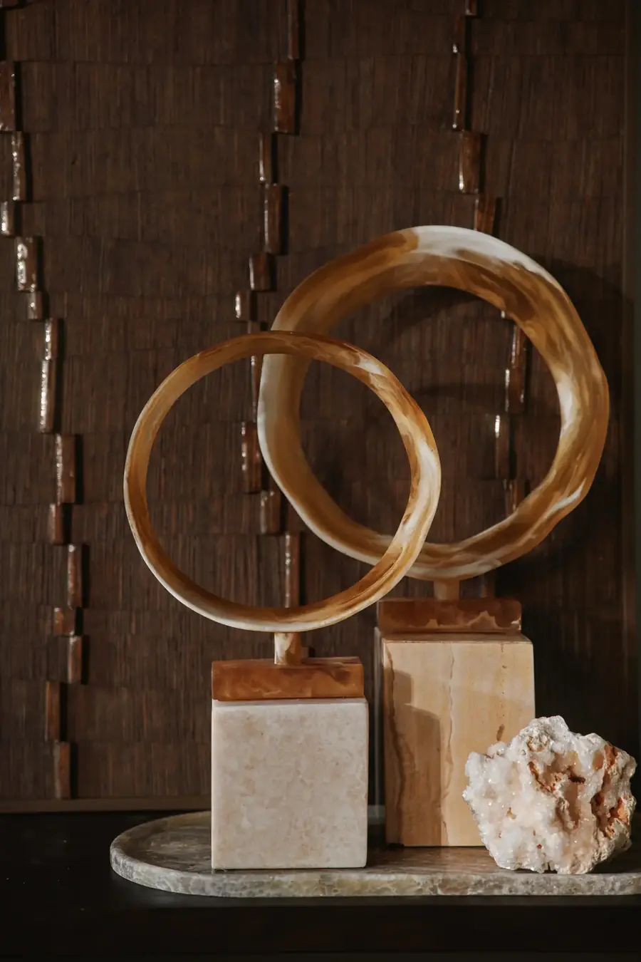 Twee onyx ringen op marmeren blokken met een stuk ruw kwarts