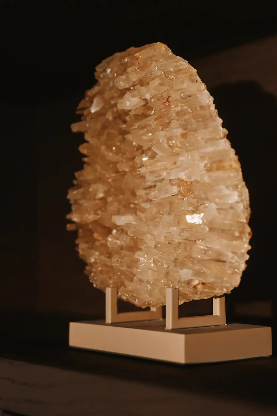 Sculptuur van ruw kwarts op een standaard in een donkere kast