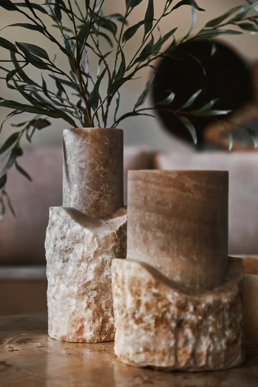 Ruwe onyx vazen met olijftakken op versteend hout