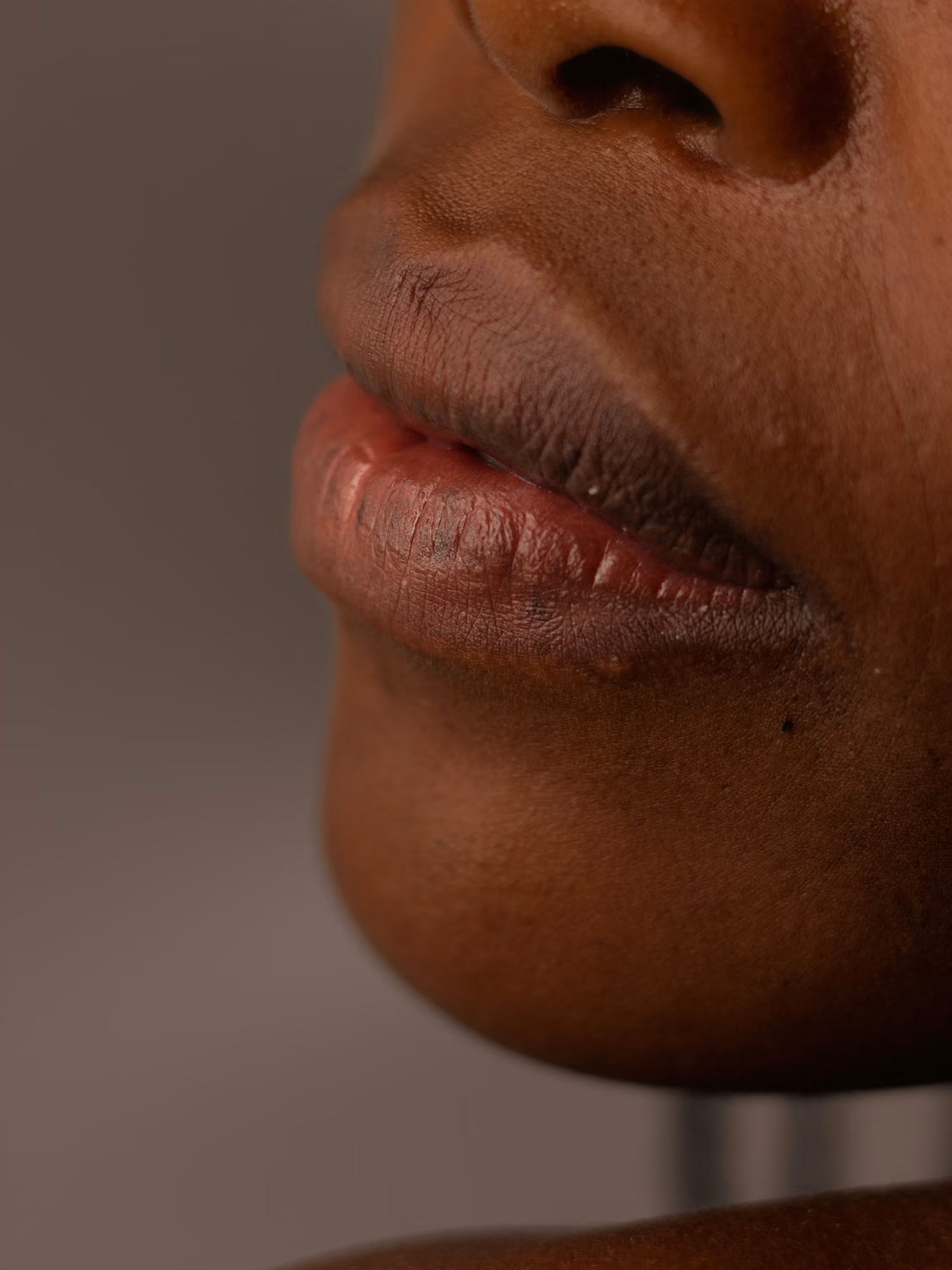 Close-up of lips and part of the nose and chin of a person with dark skin.