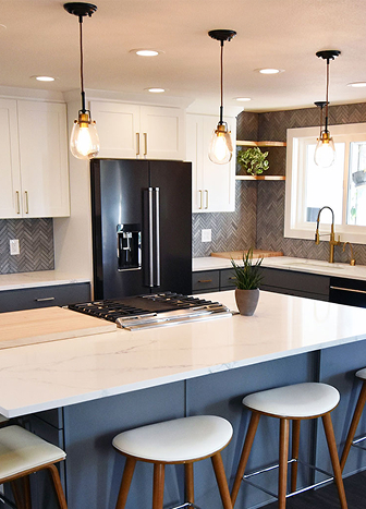 Kitchen with white cabinets, center island, black industrial pendants, and wood bar stools