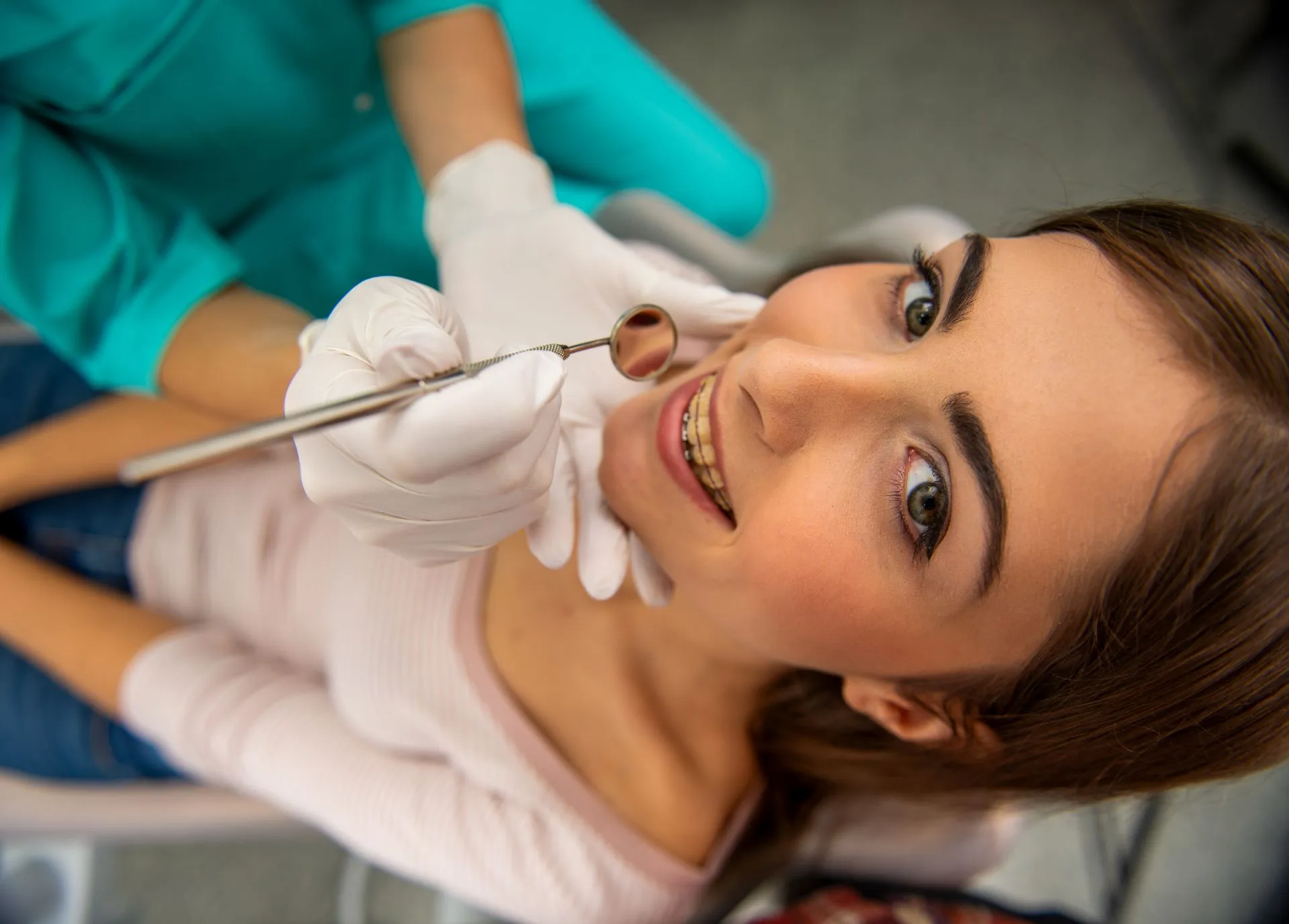 Patient holding a custom retainer used to maintain orthodontic results after braces treatment