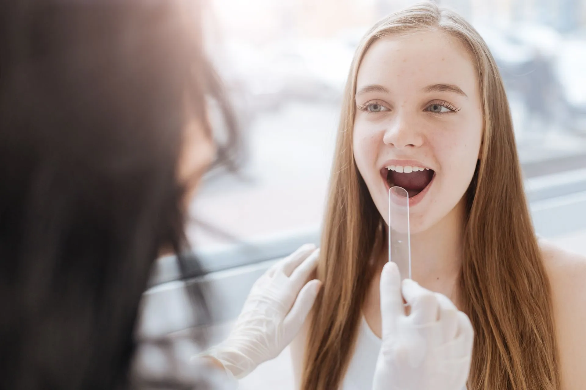 Dentist performing a quick, painless oral cancer screening during a routine dental exam