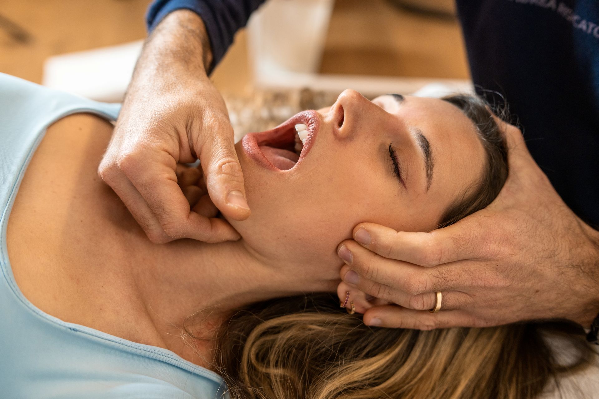 Dentist examining a patient's jaw joint during a TMJ disorder evaluation at Nova Dental Care of Vienna