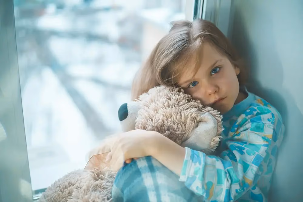 Child hugging a soft toy, stock image