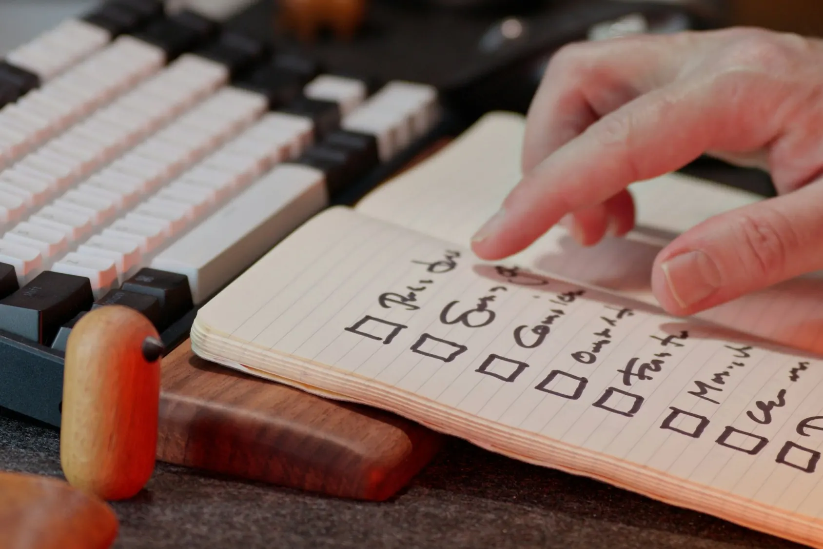 Hand working down a checklist in a notebook, stock image