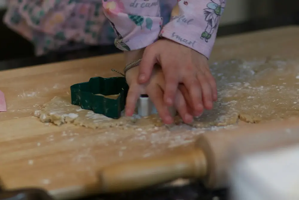 Child's hands cutting shapes from dough, stock image