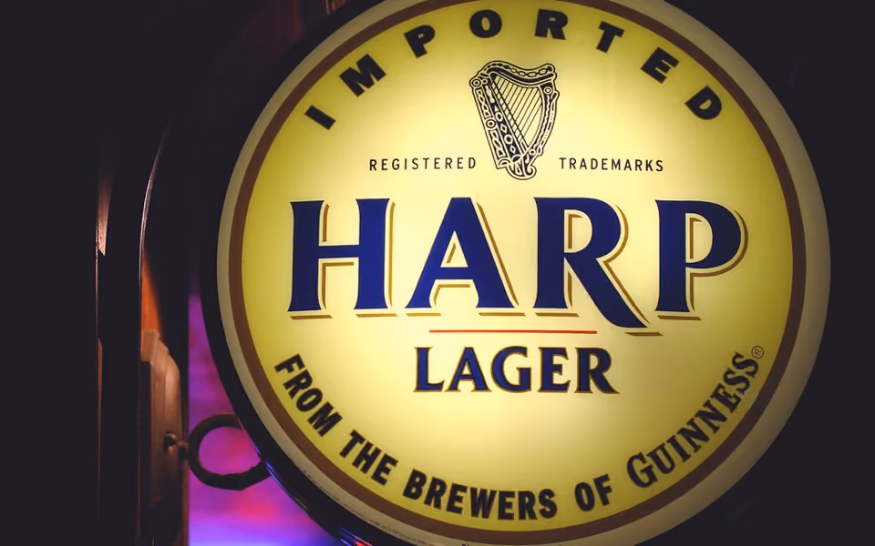 Illuminated round sign for Imported Harp Lager from the brewers of Guinness with harp logo.