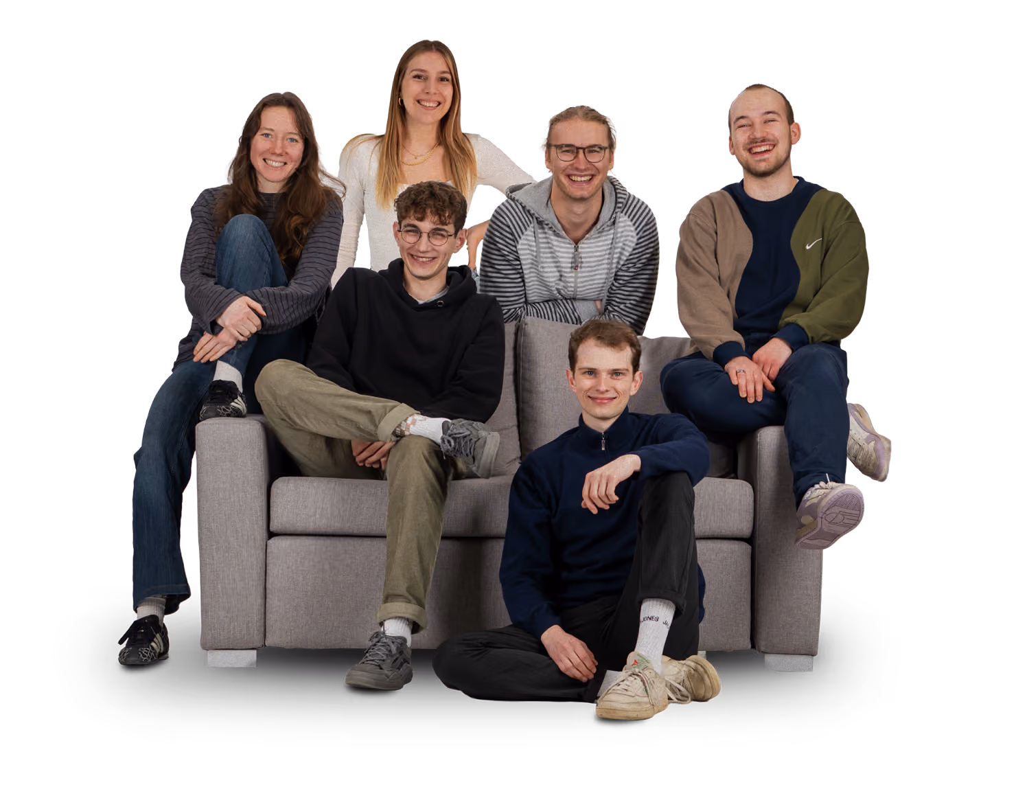 Sechs Personen des MAJOmedia-Teams sitzen lächelnd zusammen auf einem grauen Sofa.