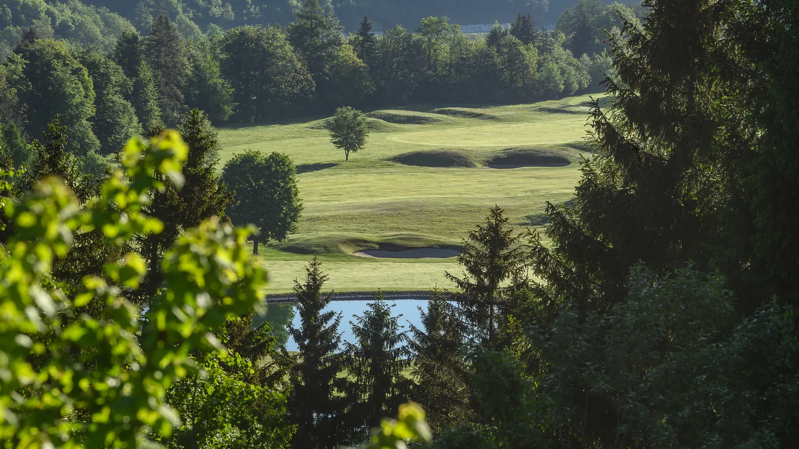 Fairways und Sandbunker des Golfclubs Senza Confini im Morgenlicht