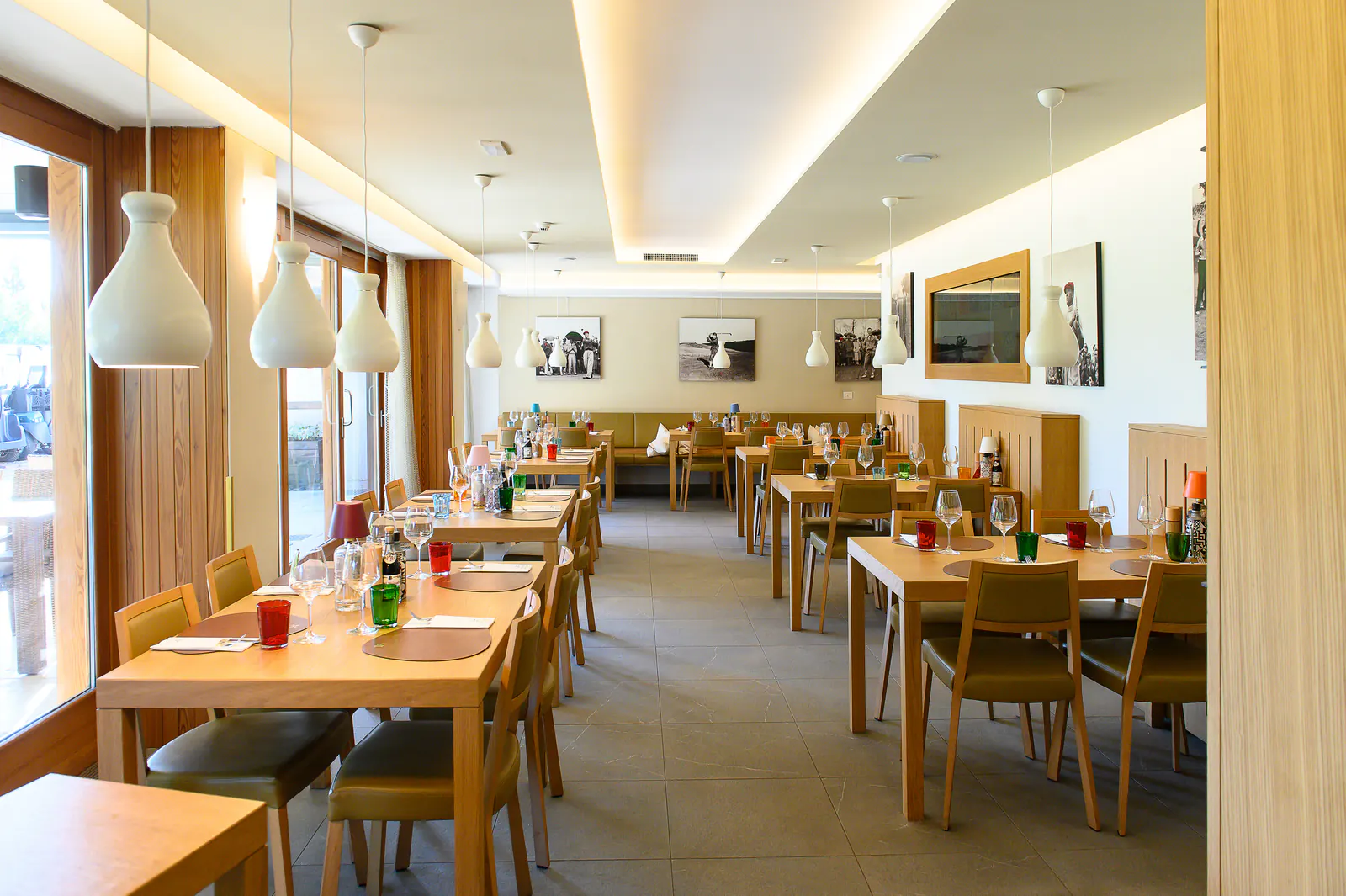 Heller Gastraum des Ristorante Senza Confini in Tarvisio mit gedeckten Tischen