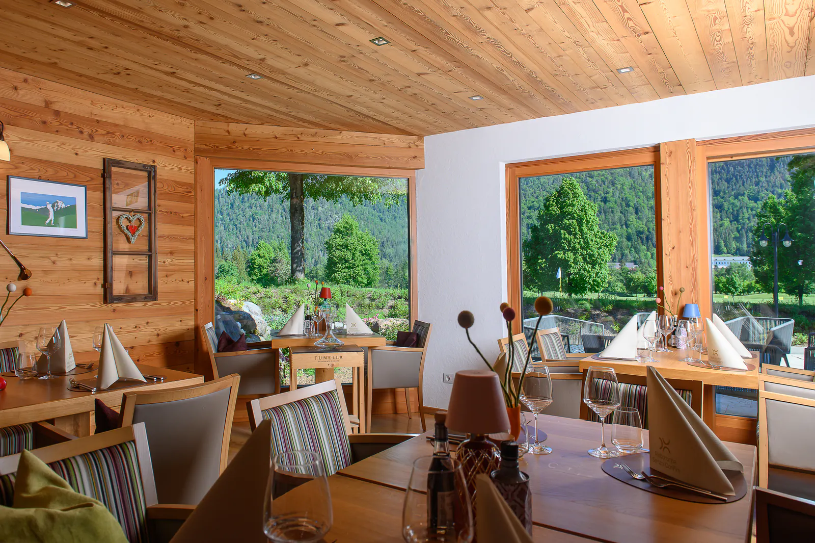 Restaurantbereich mit Panoramafenstern und Blick auf den Golfplatz in Tarvisio