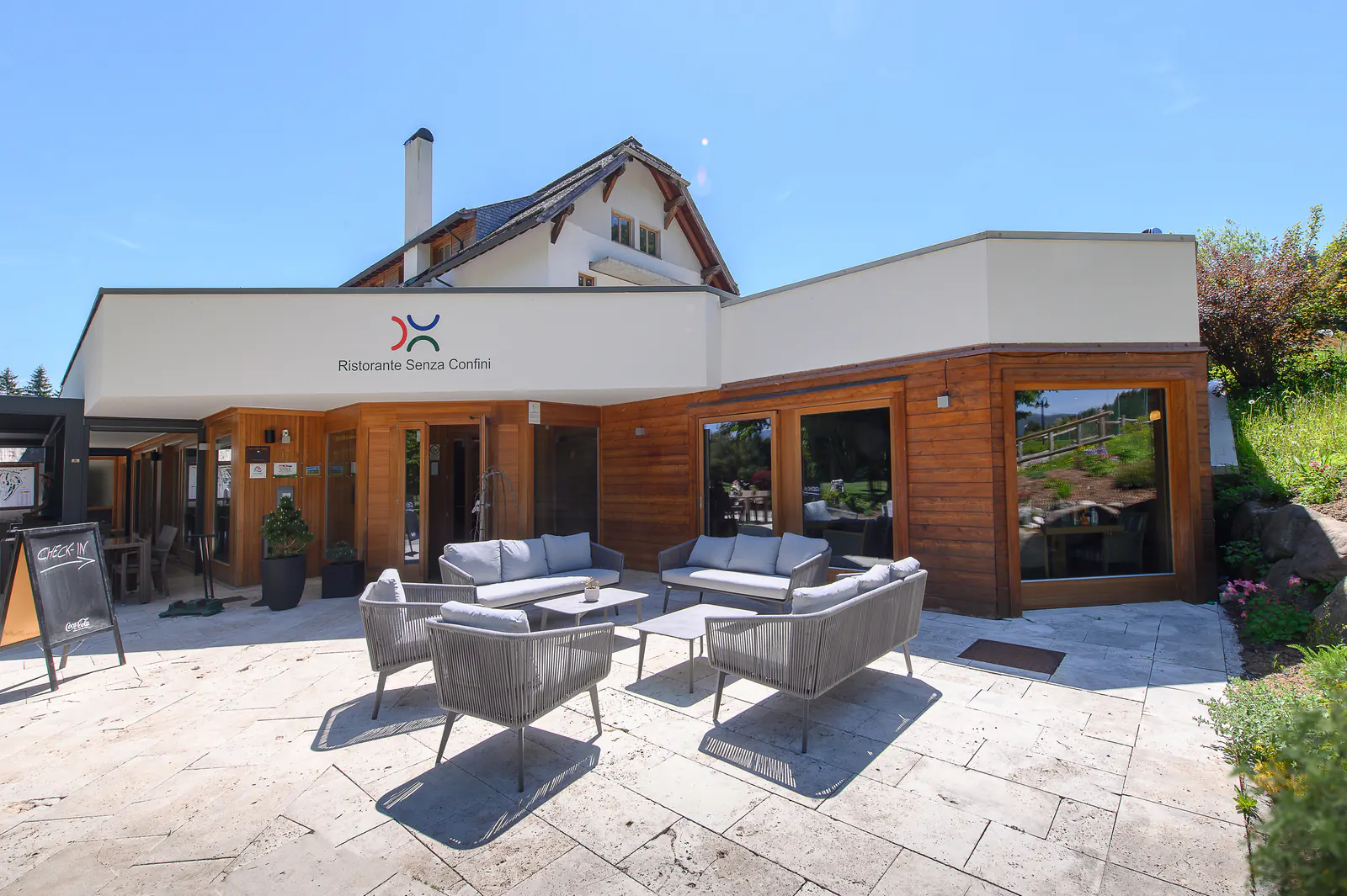 Sonnige Terrasse und Eingang des Ristorante Senza Confini am Golfplatz Tarvisio