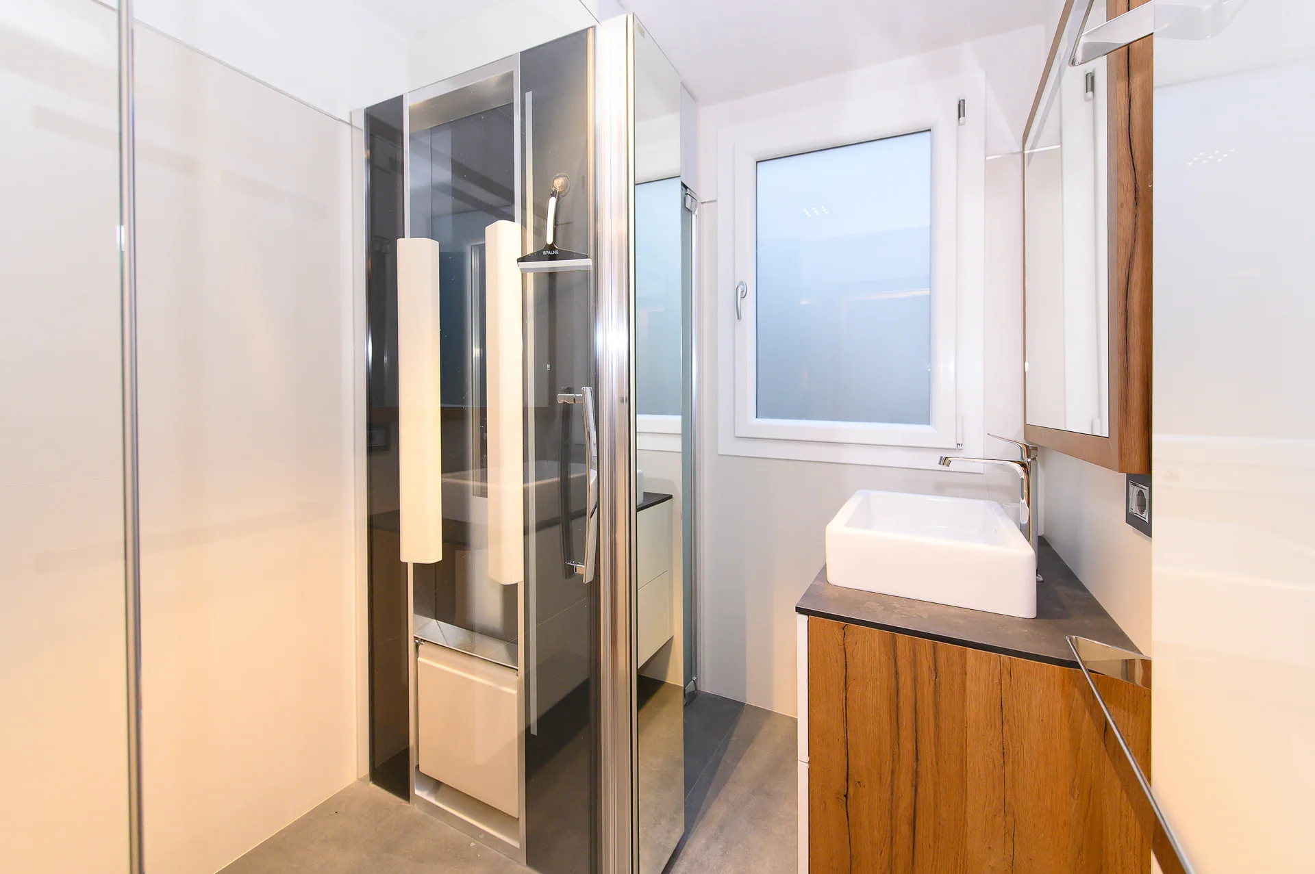 Modernes Badezimmer mit Glasdusche und Holzmöbeln