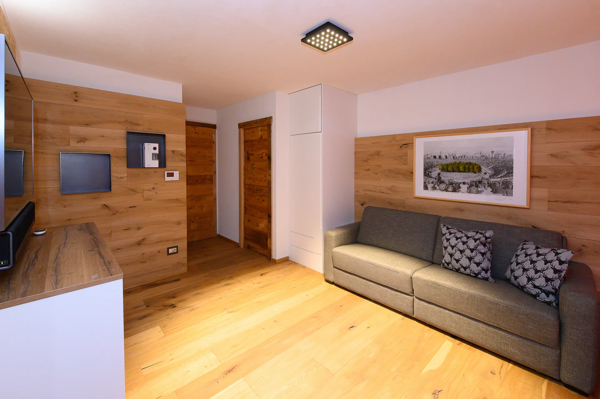 Gemütliches Wohnzimmer mit Holzverkleidung und Schlafsofa