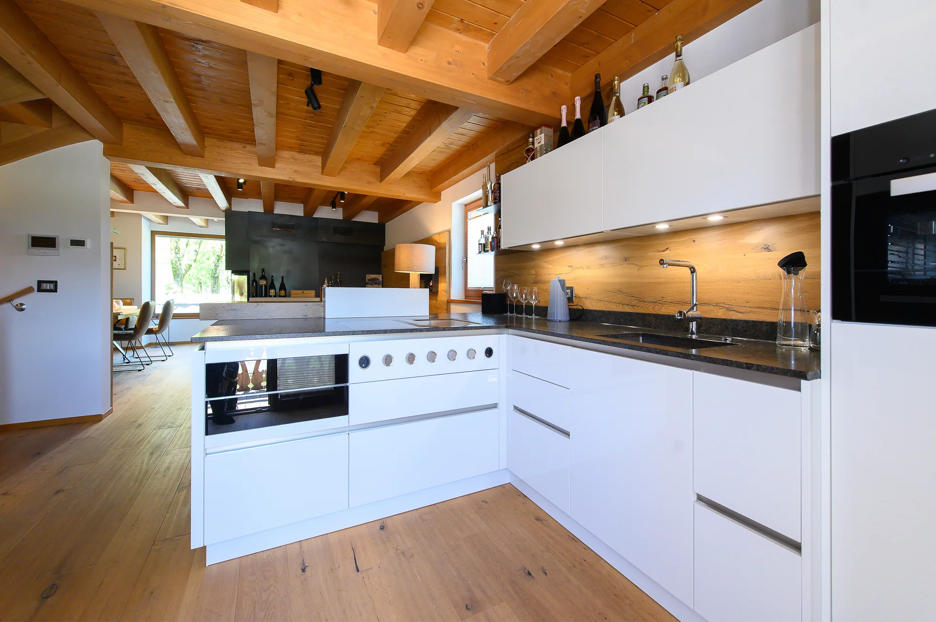 Moderne weiße Küche mit Holzdecke und hochwertiger Ausstattung