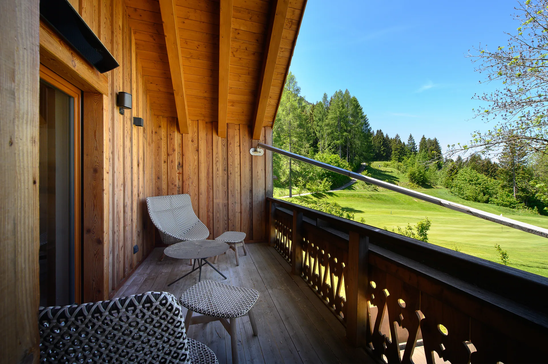 Überdachter Balkon mit Sitzgruppe und Blick auf den Golfplatz