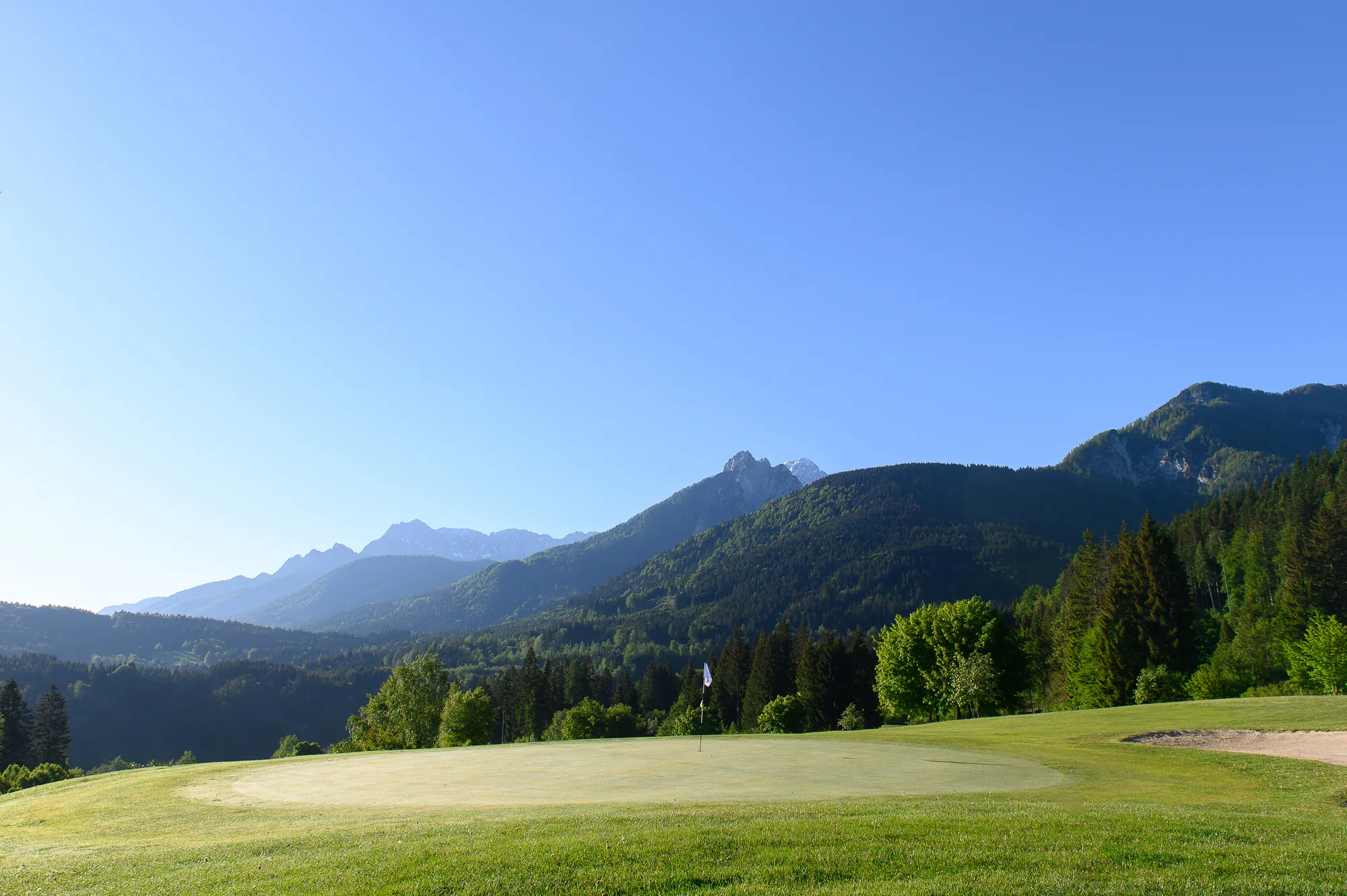 Golfgrün mit Bunker und weitem Blick auf die Julischen Alpen