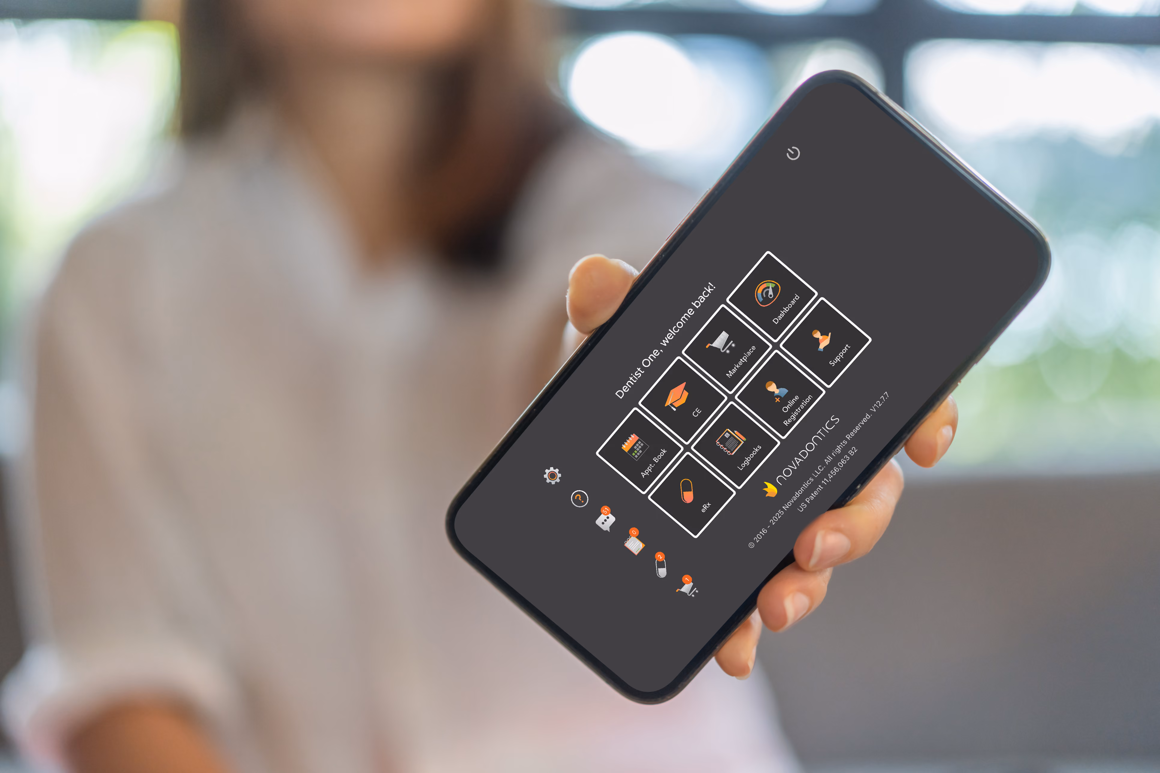 Person holding phone showing Novadontics app interface with icons like Dashboard, CE, eRx, and Support.