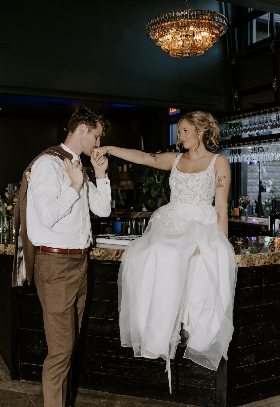 Groom kissing bride's hand at the bar at Emerson Lounge
