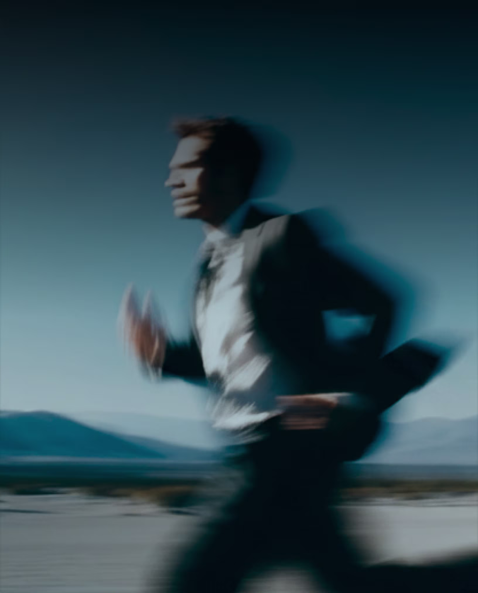 Blurred photograph of a person in a suit running outdoors