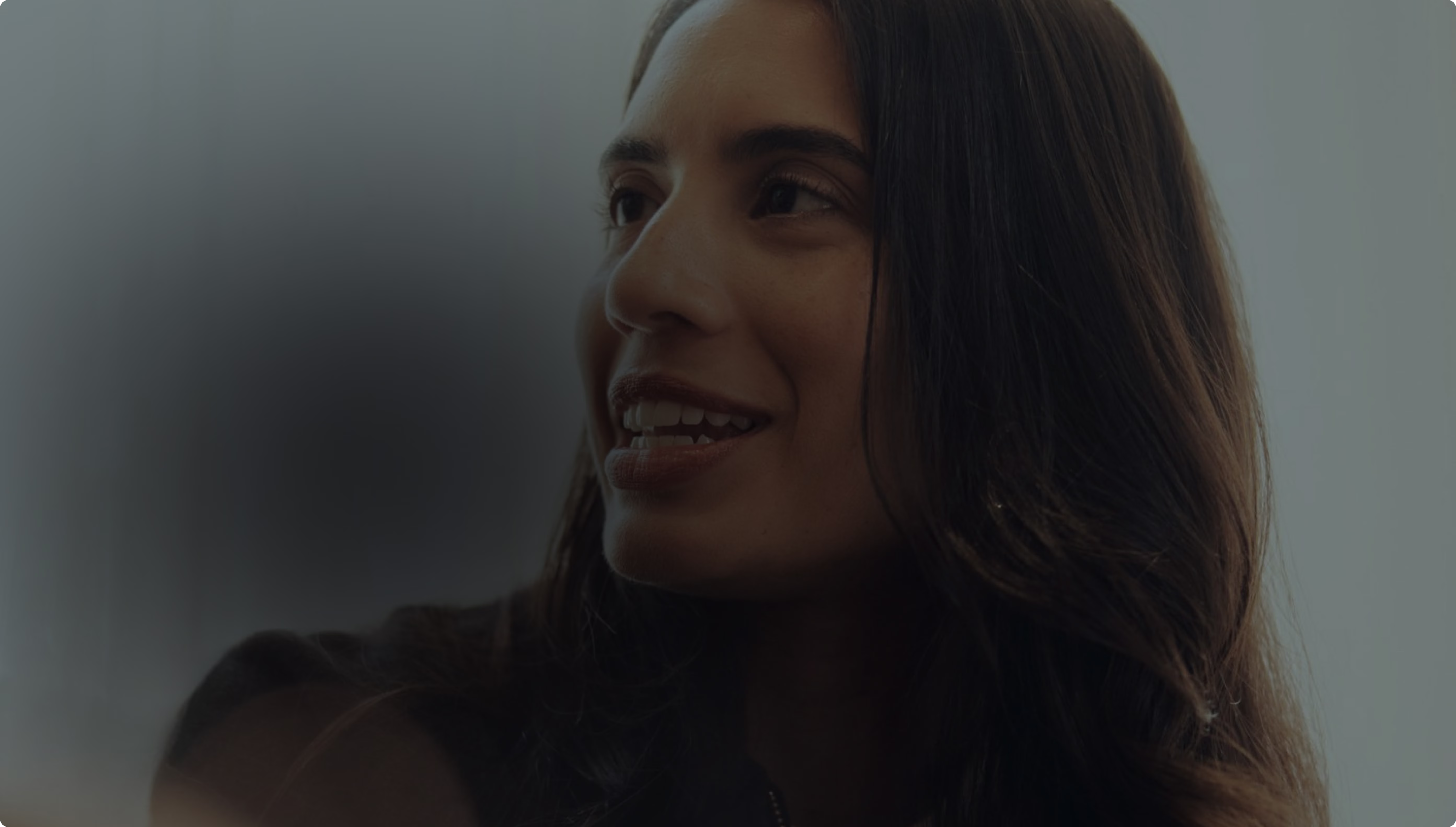 A person smiling and looking away from the camera in an office