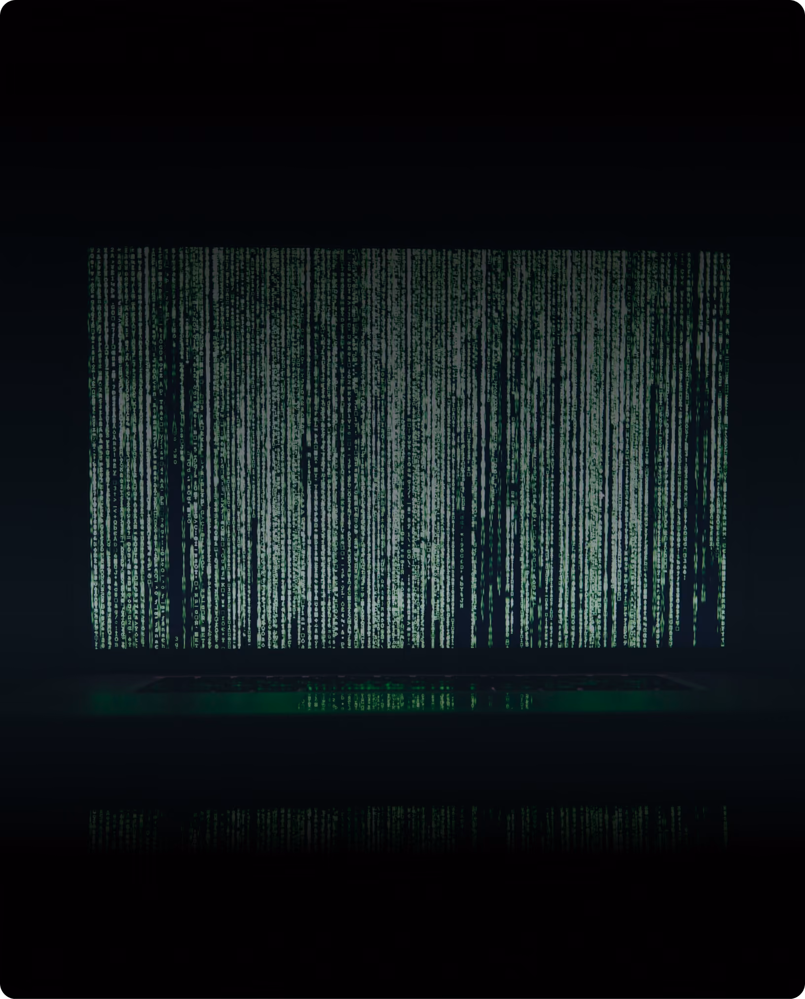 A screen filled with cascading green code in a dark room