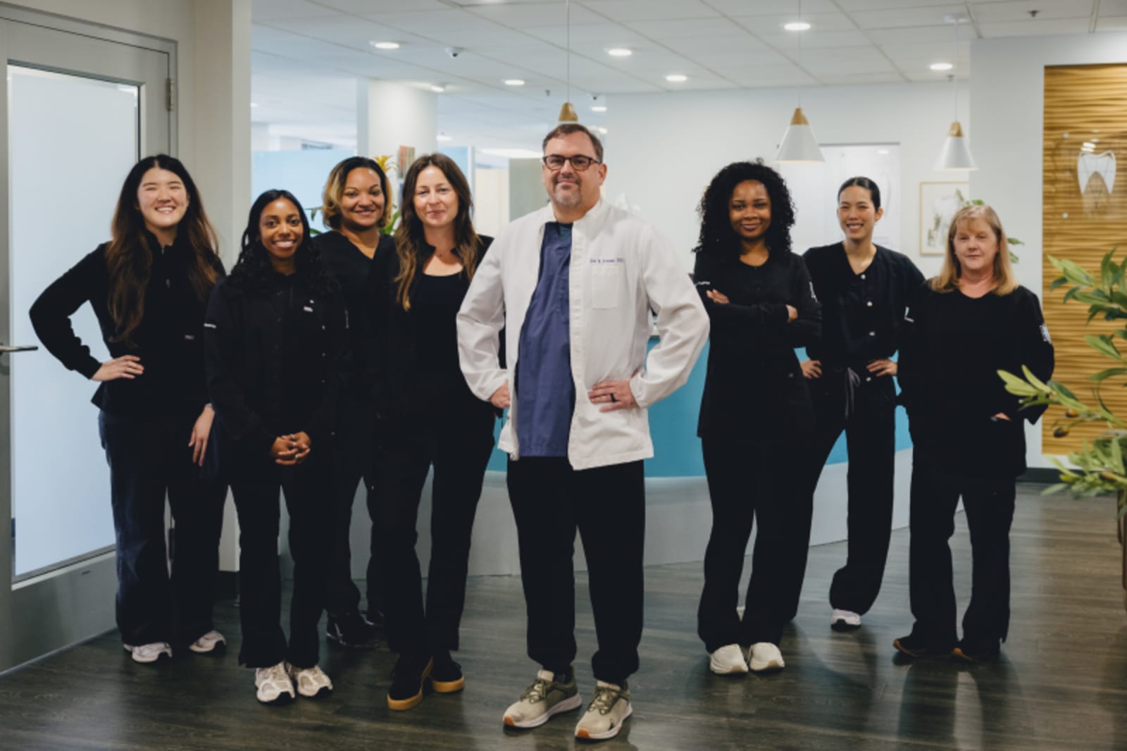 Dr. Freeman standing with diverse dental team staff in modern office hallway