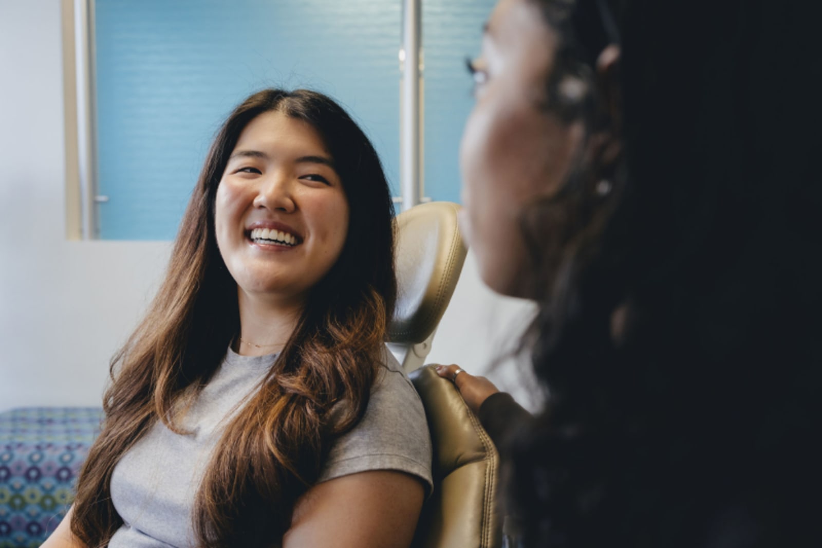 Female patient smiling during consultation with dentist in treatment room