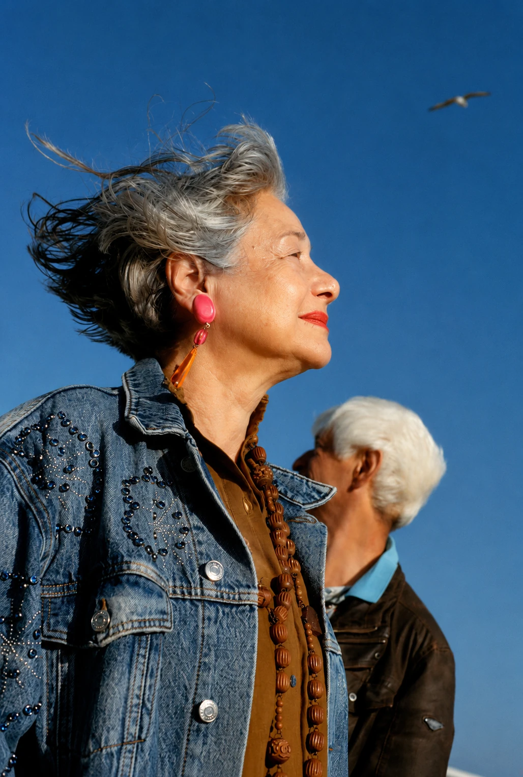 Older woman and man looking into the distance under a clear blue sky
