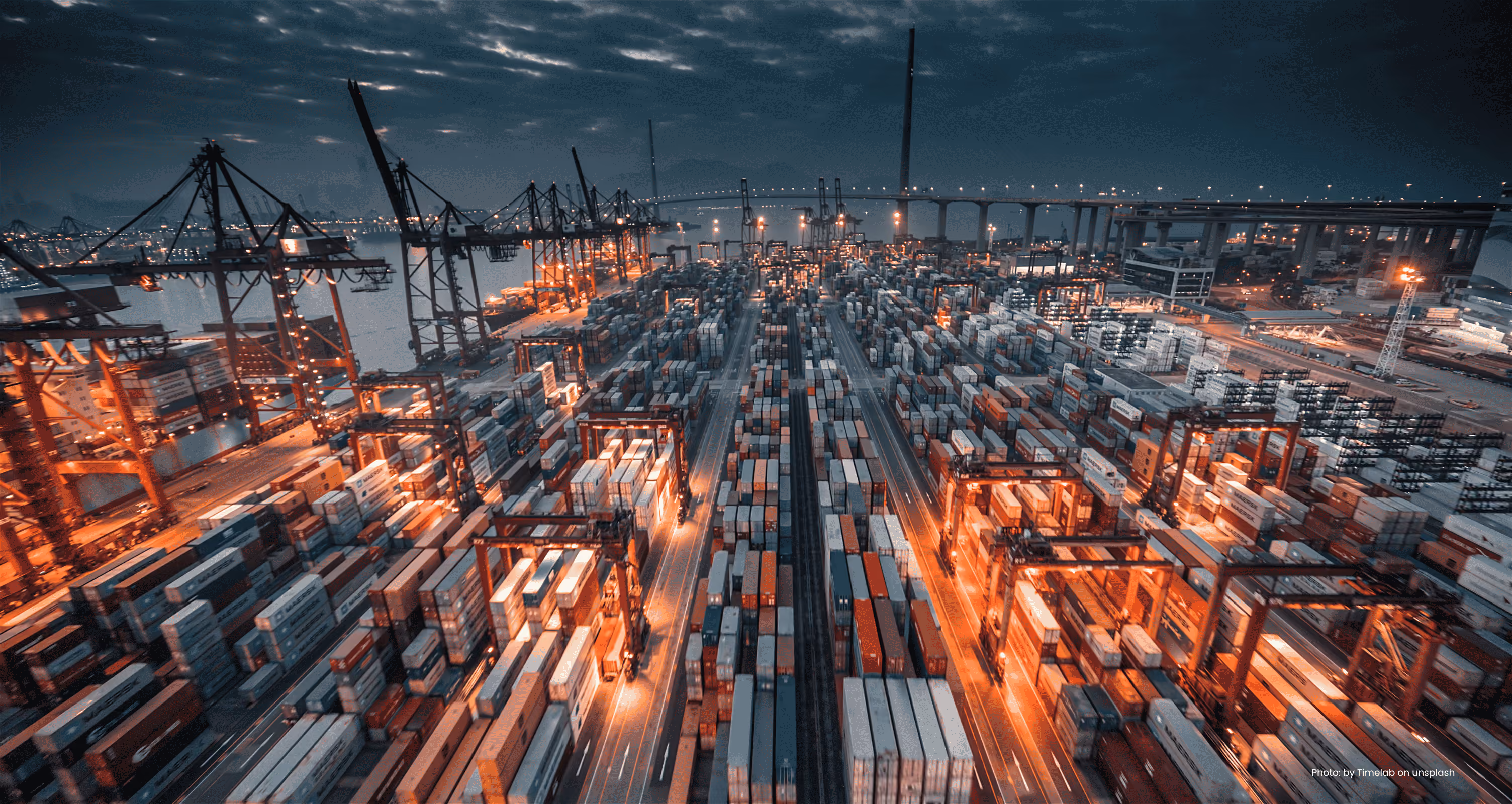 Aerial view of a container terminal stacked with shipping containers at night