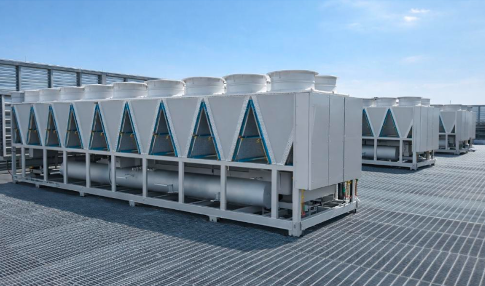 Large rooftop industrial air conditioning units under a clear blue sky on a metal grid surface.