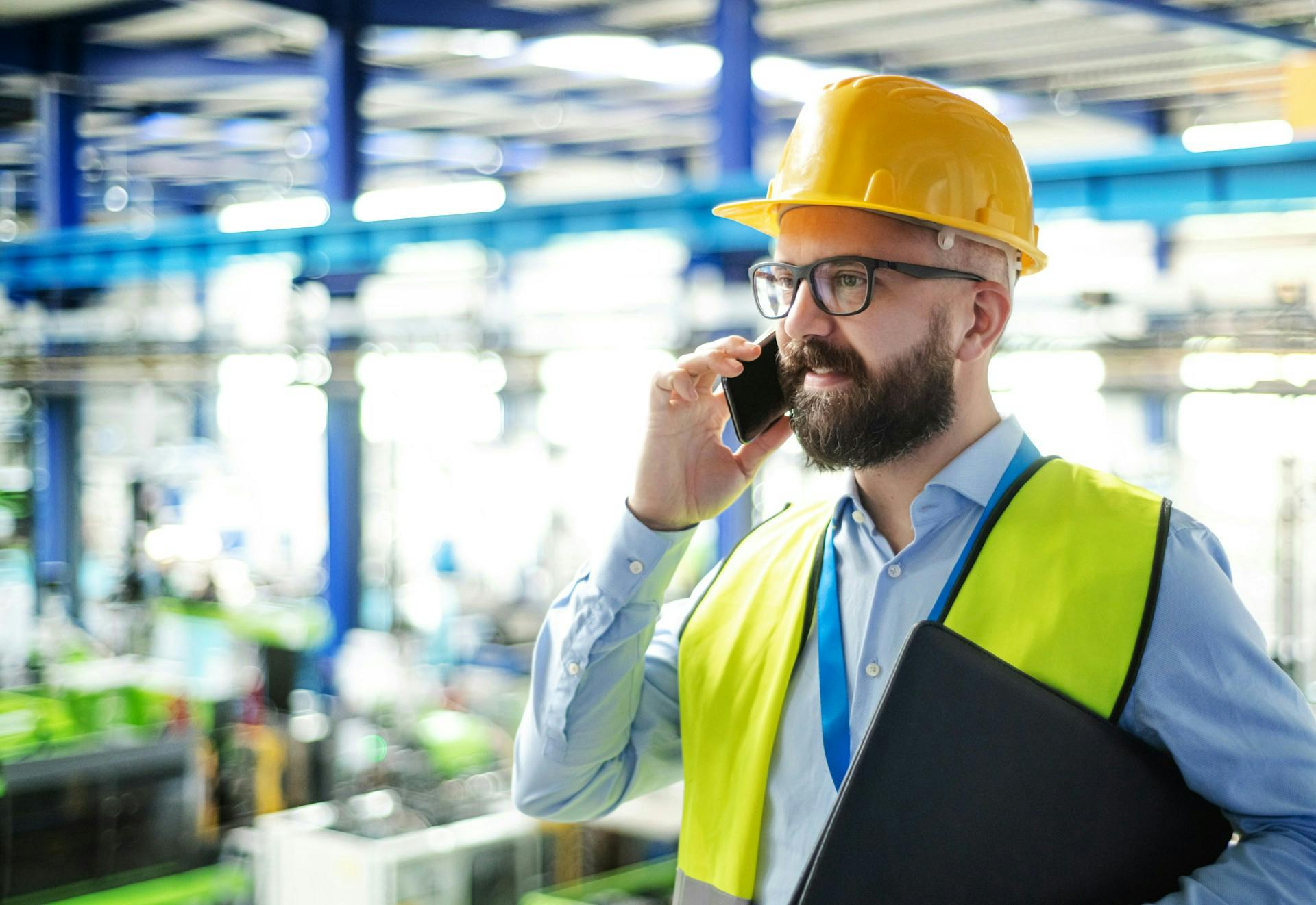 worker wearing a helmet talking on the phone