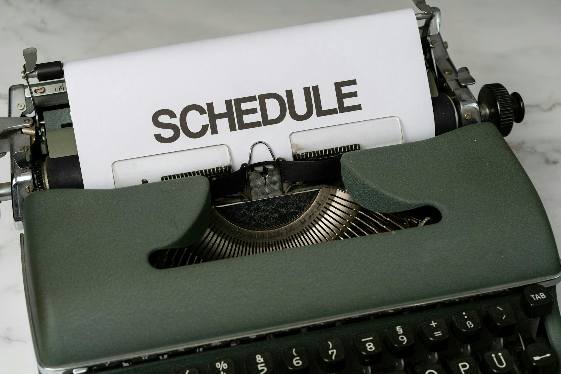 Typewriter with a sheet of paper displaying the word SCHEDULE.