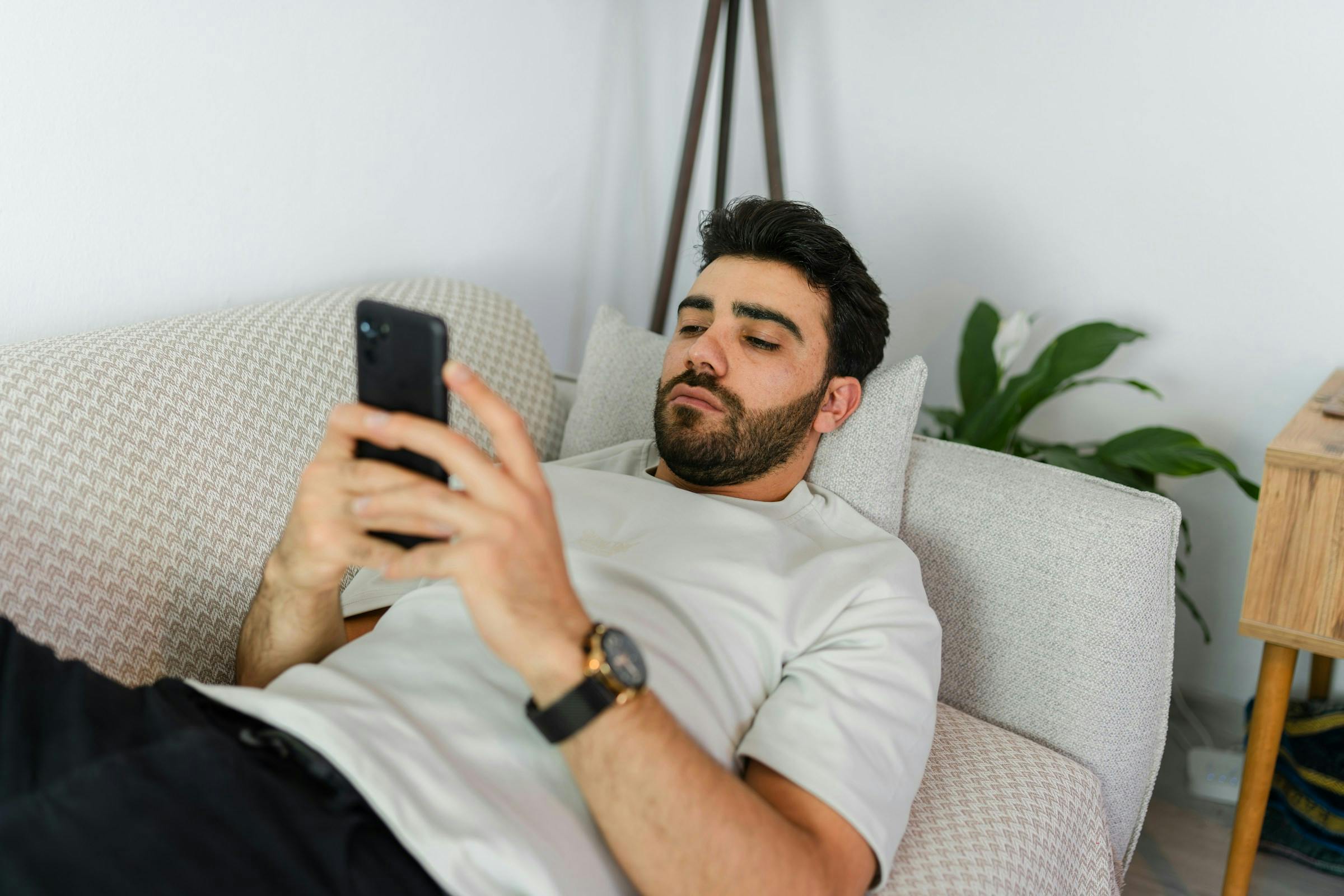Man reclining on a sofa in a living room.